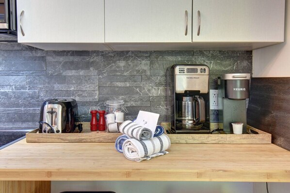 A kitchen with a coffee maker, toaster, and salt and pepper shakers. - Cozy Lodge in the Mont Tremblant Ski Village (Mont-Tremblant)