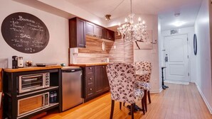 A modern kitchen with dark wooden cabinets, a built-in oven, and a chalkboard menu.