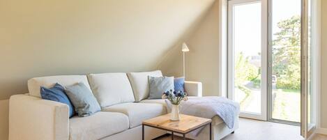 A modern living room with a sofa, a small wooden table, and a floor lamp.