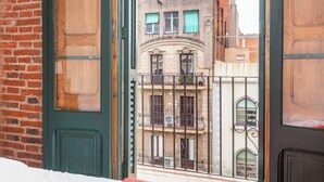 A view through a green door with a metal gate, leading to a building with multiple balconies and windows. - Classic Style Apartment by Sagrada Familia With Balcony and (Barcelona)