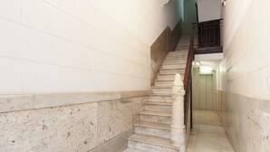 Eine Marmortreppe mit Handlauf, die zu einer oberen Etage führt.