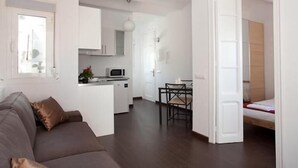 A compact living space with a kitchenette, a dining area, and a sleeping area.