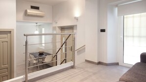 Um interior moderno com escada, área de jantar e uma janela grande.