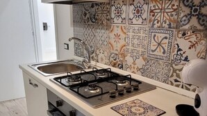 A kitchen with a gas stove, oven, and a decorative backsplash. - Delizioso Appartamento, Totalmente Ristrutturato 5 Posti Letto (Palermo)