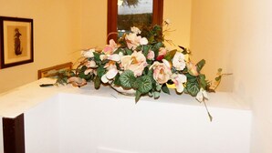 A white reception desk with a floral arrangement and a framed picture on the wall. - Private Villa with hot tub, WIFI, private pool, A/C, TV, terrace, panoramic view, close to Sirmione (Polpenazze Del Garda)