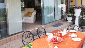An outdoor dining area with a table set for two, featuring a checkered tablecloth, plates, cutlery, and a pitcher of water. - Private Villa with hot tub, WIFI, private pool, A/C, TV, terrace, panoramic view, close to Sirmione (Polpenazze Del Garda)