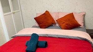 A bed with a red blanket and pillows in shades of orange and pink. - mater dei <br>suite near royal Liverpool hospital (Liverpool)