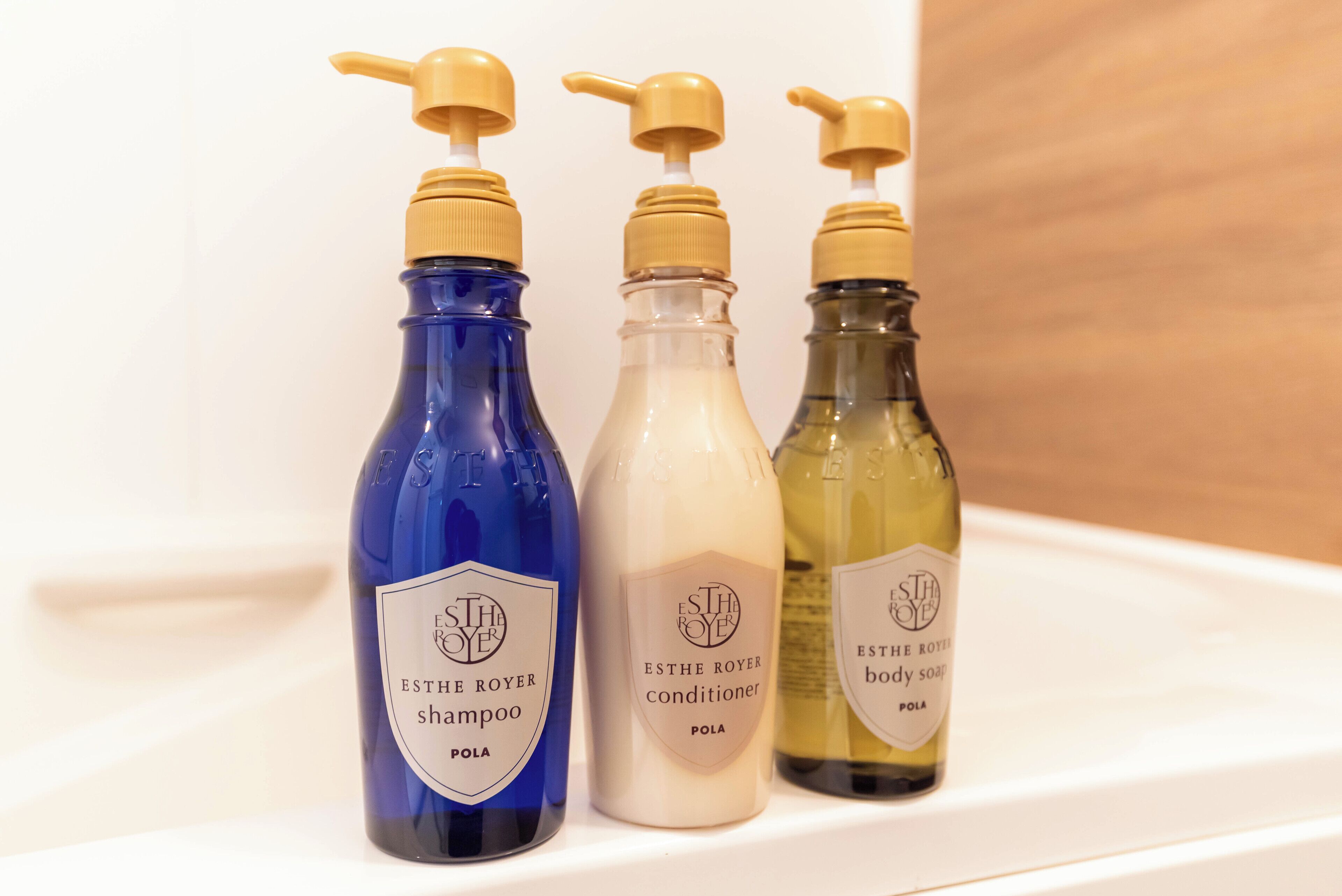 Three bottles of ESTHE ROYER products on a white shelf.