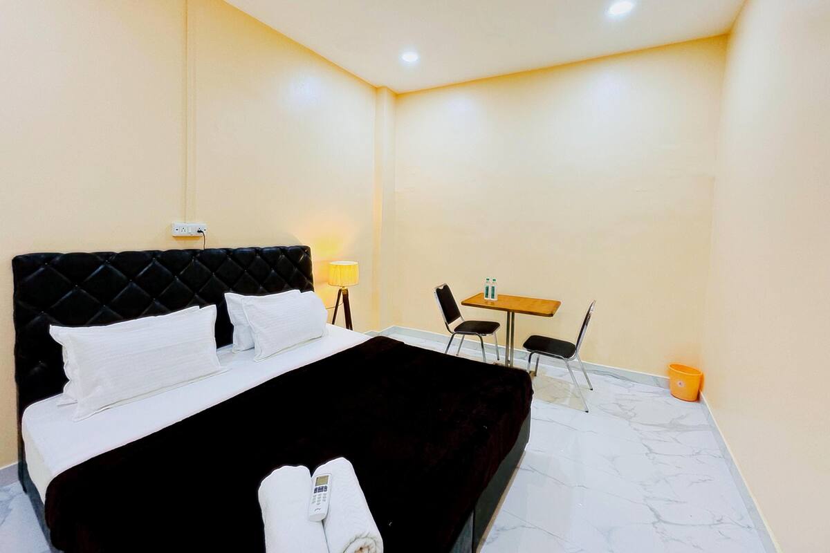 Une chambre d’hôtel avec un lit, un bureau et une chaise.
