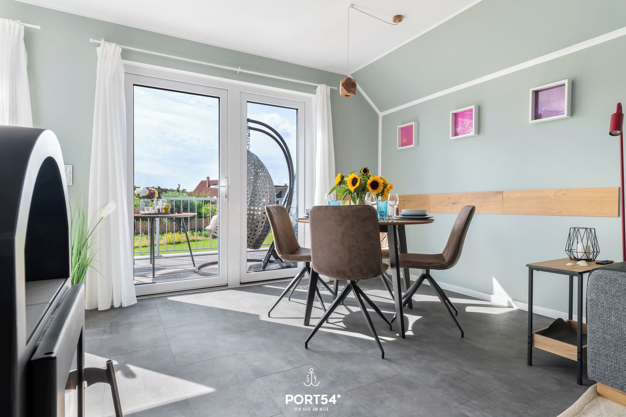 Una sala de estar moderna con comedor, amplios ventanales correderos a un balcón y vistas al exterior.