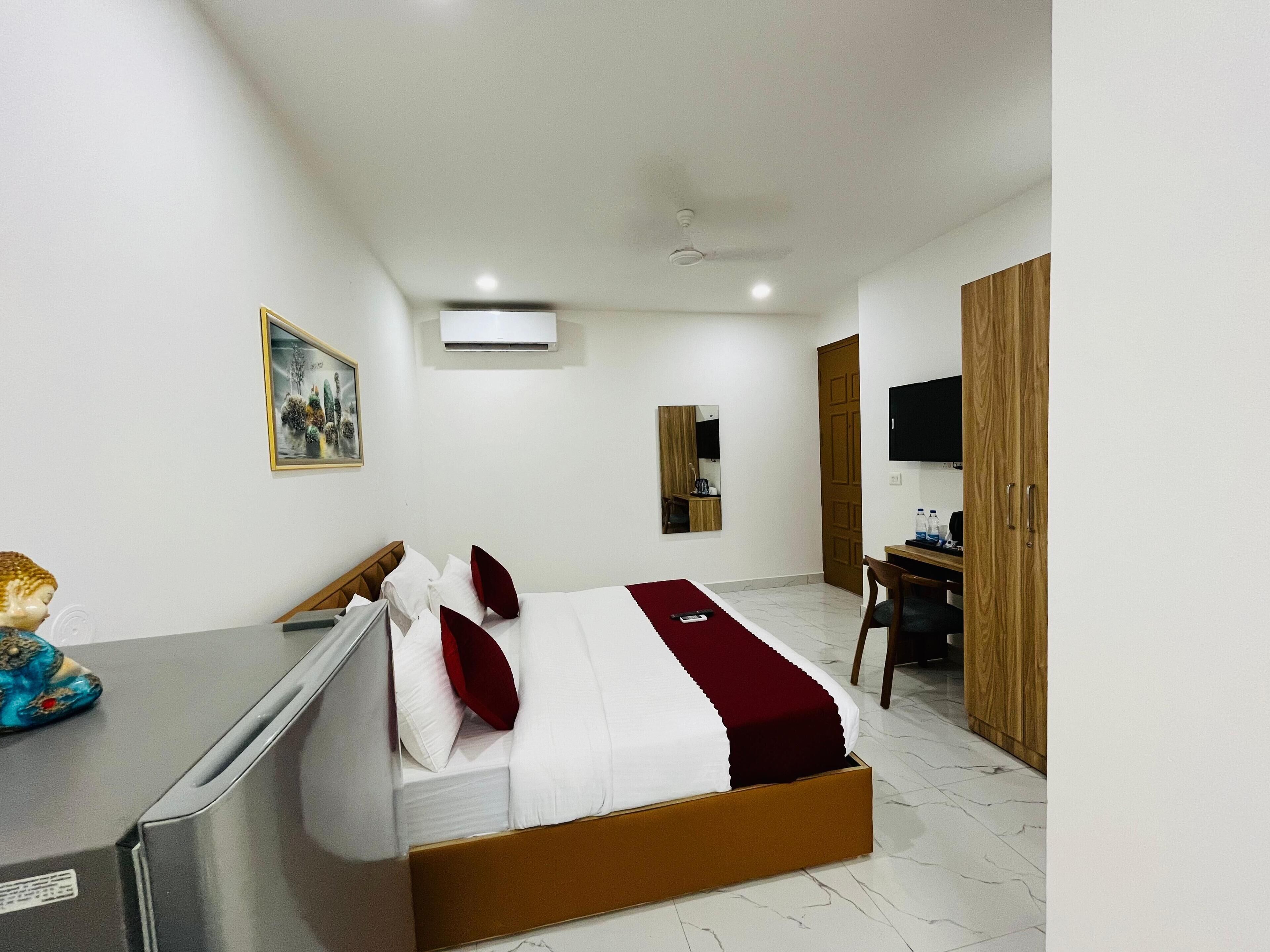 Une chambre d’hôtel comprenant un lit, un bureau, une chaise, une télévision et une armoire.
