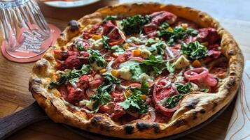 A pizza with various toppings on a wooden table.