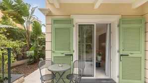 A patio with a table and chairs, a sliding glass door, and green shutters. - Suite Odyssée 2 - Five Star Holiday House (Saint-Jean-Cap-Ferrat)