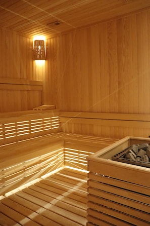 A wooden sauna with benches and a central heating element. - Riva Hotel Nisantasi & Spa (Istanbul)