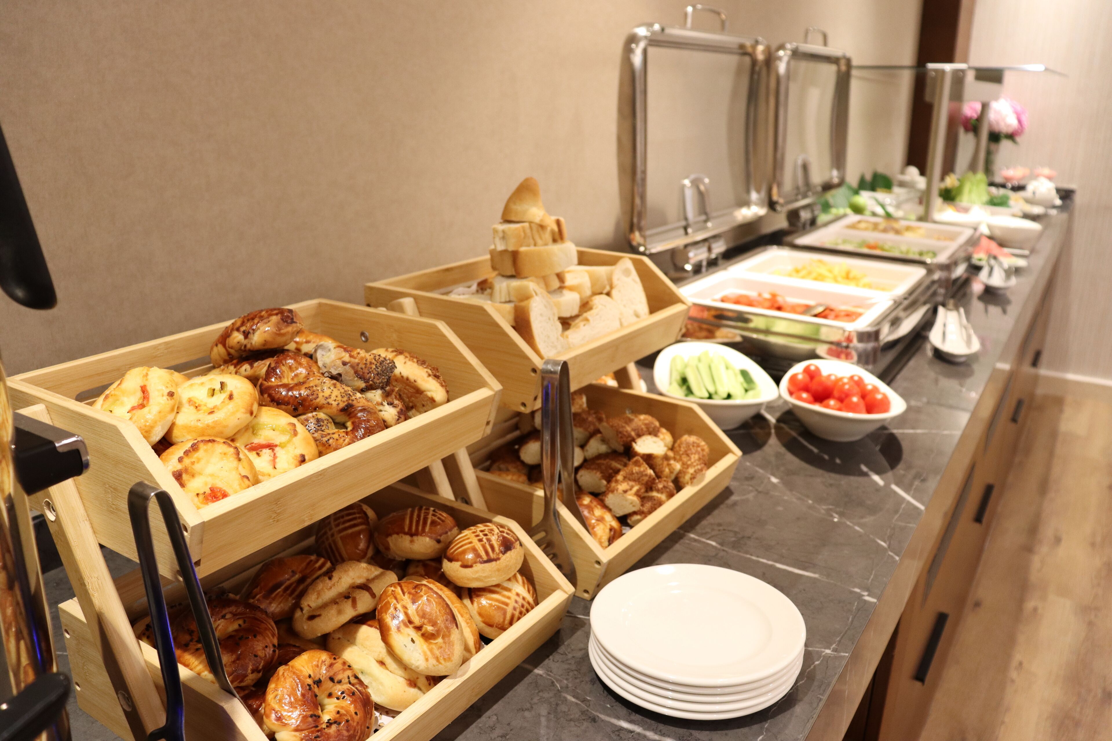Un buffet proposant une variété de plats et des plateaux de service en bois.