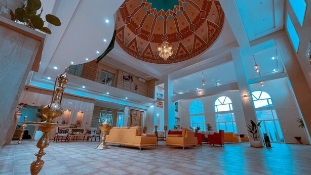 A spacious lobby with a high ceiling, a large chandelier, and a central seating area with sofas. - Capsa Thermal Oasis (Gafsa)