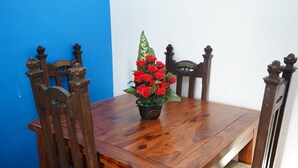 A wooden dining table with a potted red flower arrangement. - 59B Comfortable Home Sleeps 8 (Hounslow)