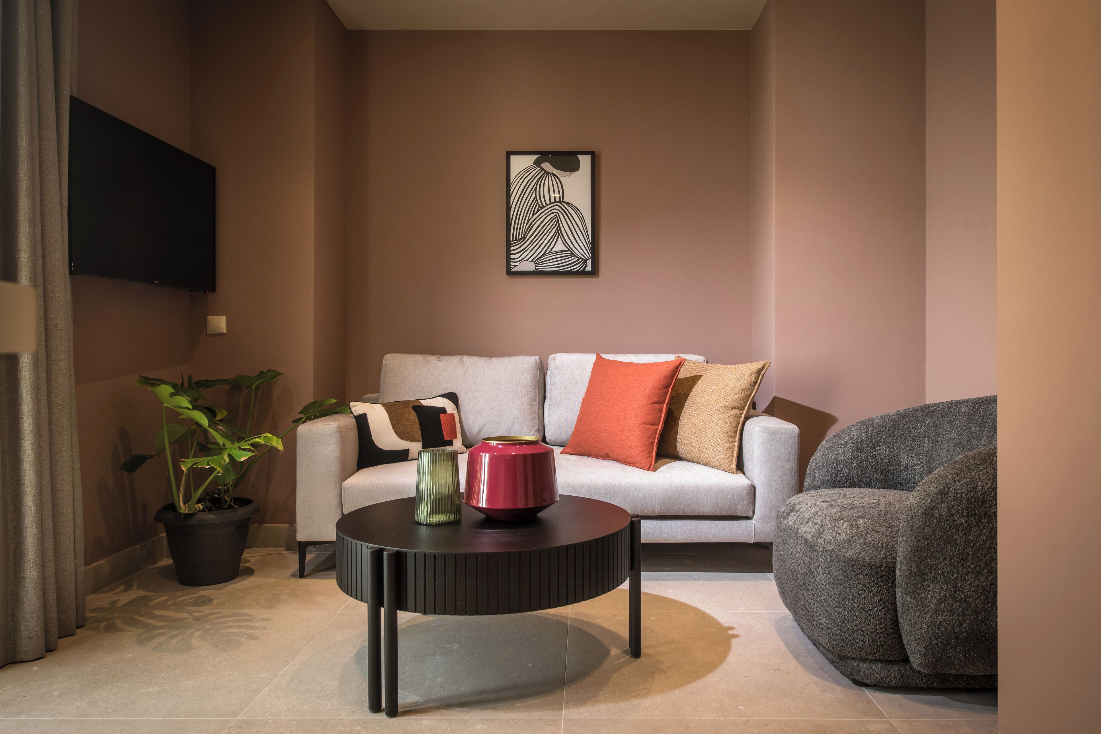A modern living room with a sofa, a coffee table, and a potted plant.