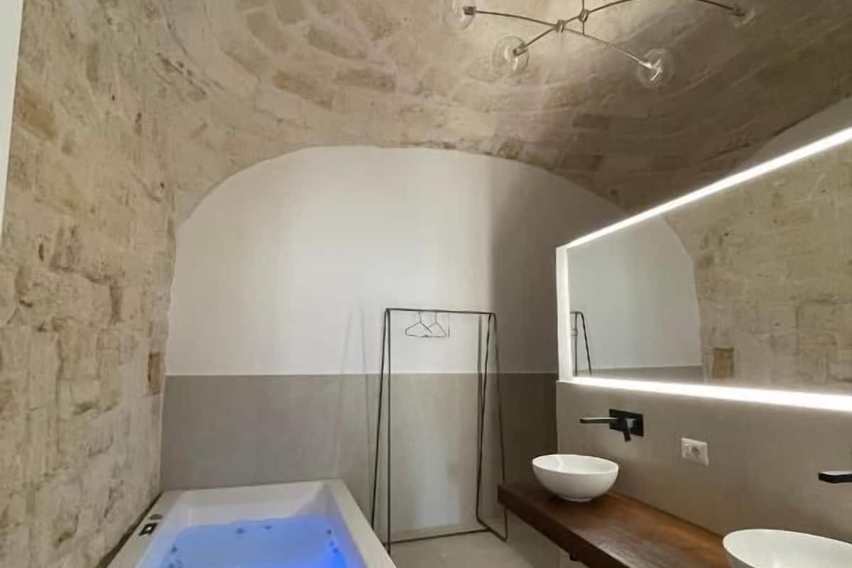 Ein modernes Badezimmer mit einer freistehenden Badewanne, einem großen Spiegel und einem hölzernen Waschtisch.