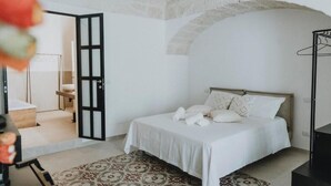 Une chambre à coucher comprenant un lit, une armoire et une porte donnant sur une autre pièce.