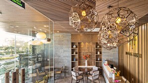 Un interno moderno con una reception, un'area salotto e una parete di vetro che offre vista sull'esterno.