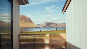 A room with a view of a lake and mountains.