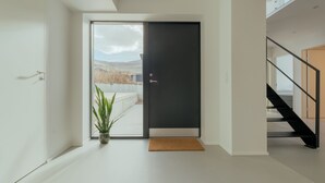 A modern interior with a sliding glass door leading to a view of a snowy landscape.
