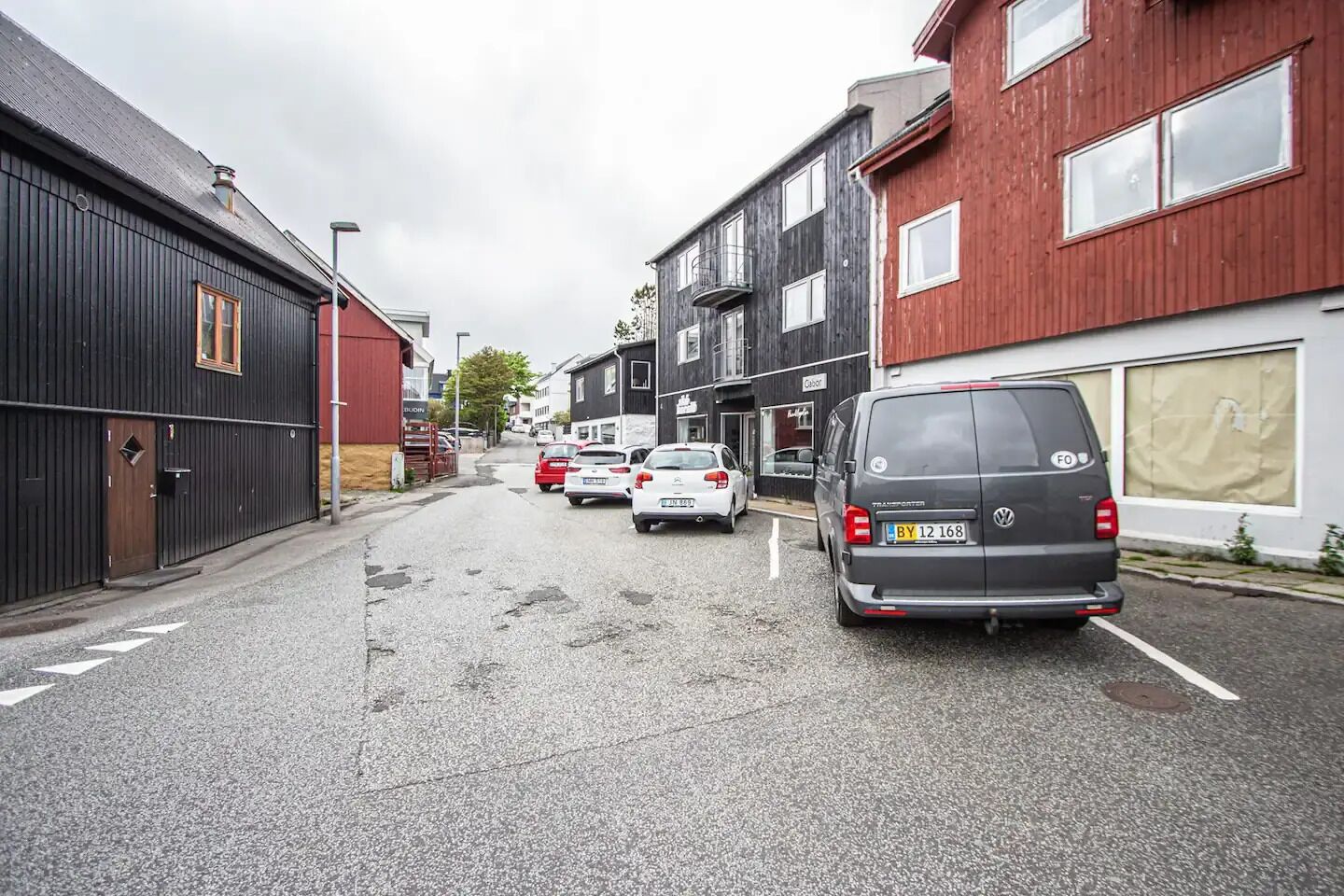 Eine Straße mit parkenden Autos und Gebäuden.