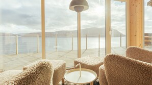 Un coin salon confortable avec vue sur un lac et des montagnes.
