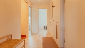A hallway with a wooden bench, a door with a towel rack, and a light fixture on the ceiling. - Charming Central Tórshavn Retreat - 2Br Apartment (Tórshavn)