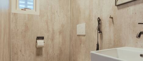 A bathroom with a toilet, sink, and mirror.