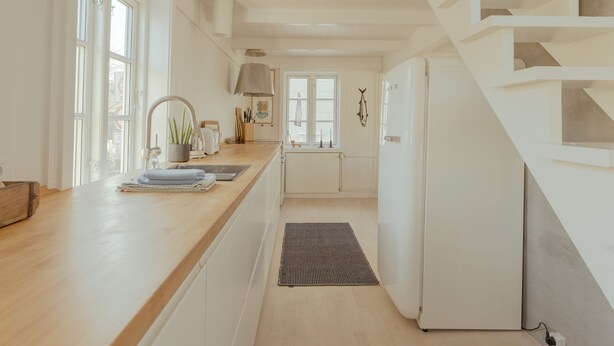 A modern kitchen with wooden countertops, a built-in stove, and a refrigerator. - Charming Retreat In The Heart Of Tórshavn (Tórshavn)