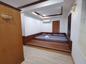 A room with a built-in sofa bed, a wooden wardrobe, an air conditioning unit, and a window with blinds. - Seremban Resort Villa by uBook (Seremban)