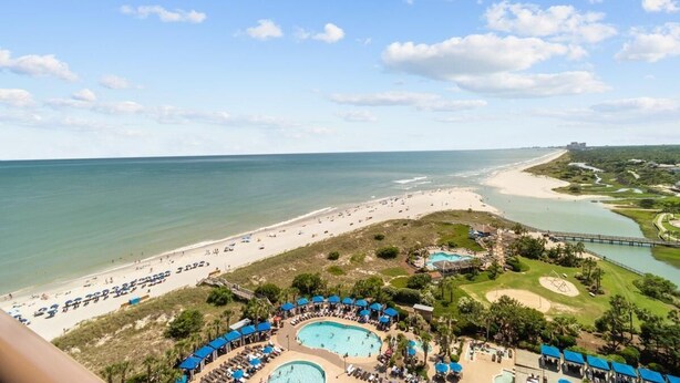 Ein Resort mit mehreren Schwimmbecken, einem Strand und einem Golfplatz.