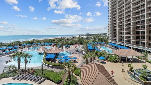 A resort with multiple swimming pools, a beach view, and a large building with balconies. - Shoreline Sunsets: 2BR Condo with Modern Comforts (North Myrtle Beach)