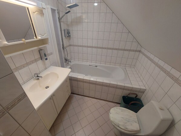 A bathroom with a bathtub, a sink, and a toilet. - Buk City Apartments  (Buk)