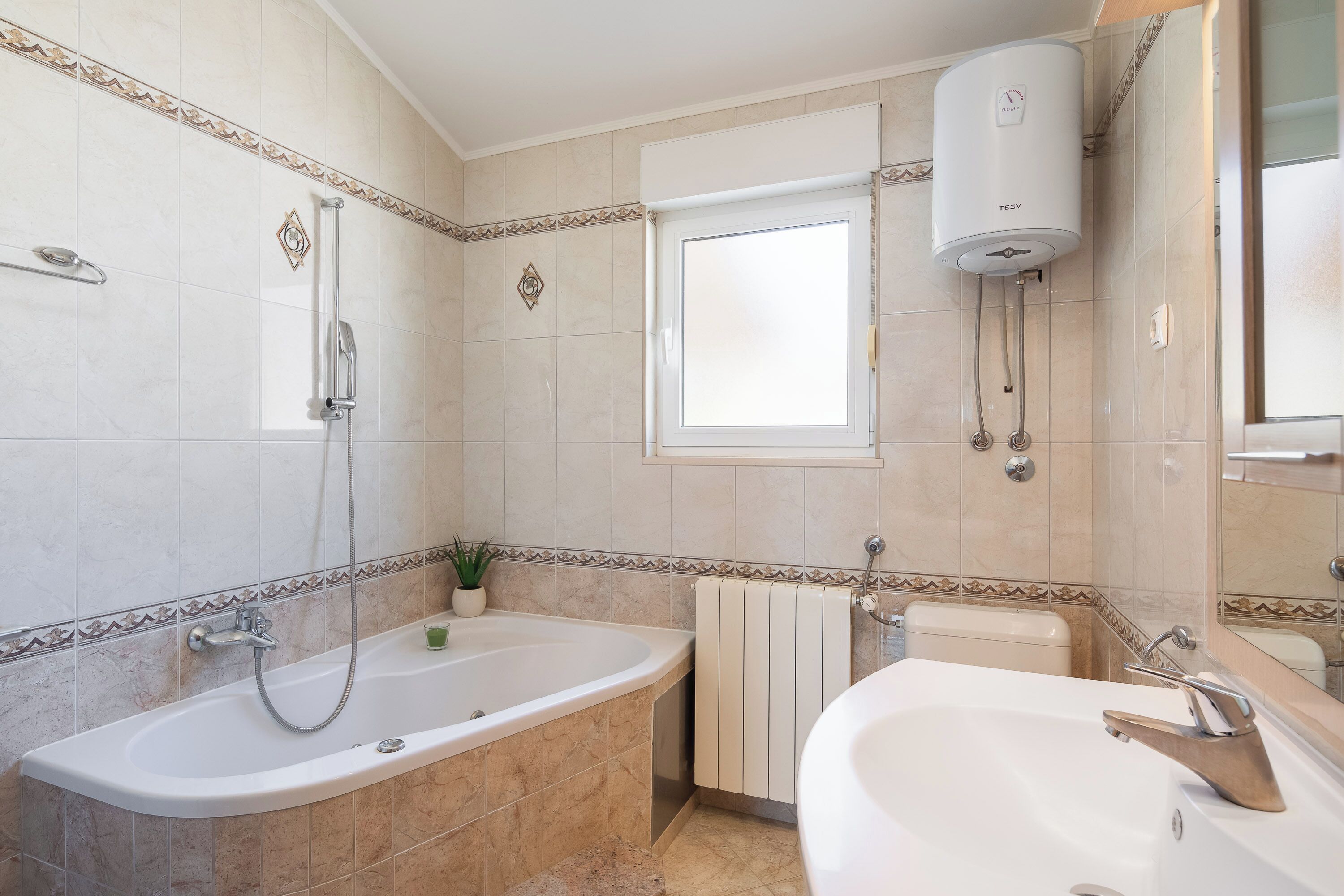 Un baño con bañera, ducha, inodoro y lavamanos.