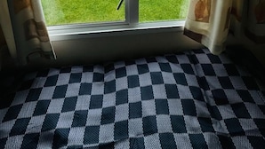 Une pièce dotée d’une grande porte-fenêtre coulissante qui donne sur un espace extérieur verdoyant.