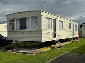 A mobile home with a "TORINO" sign, a "SUPER 35" label, and a small porch with steps.