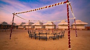 Un camp de yourtes traditionnel, avec un espace central aménagé en salon et des yourtes en arrière-plan.
