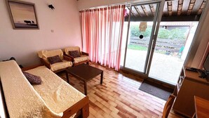 A living room with a sofa set, a coffee table, and a sliding glass door leading to an outdoor area. - Charming 3-Room, 6 Pers., Sea Front, Parking (Cap d'Agde)