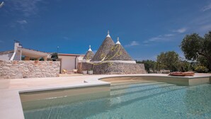 A swimming pool with a stone building in the background. - TD Trulli Benedetta w Pool in Peaceful Nature (Castellana Grotte)
