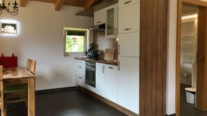 A modern kitchen with white cabinets, a wooden countertop, and a built-in oven. - Apartment Silver Moon (Leutasch)