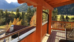 A wooden balcony with a view of a mountainous landscape and autumn foliage. - Apartment Silver Moon (Leutasch)