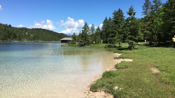 A serene lakeside setting with a small cabin and dense forest. - Apartment Silver Moon (Leutasch)