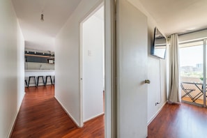 Un pasillo que conduce a una cocina y un balcón con vistas.
