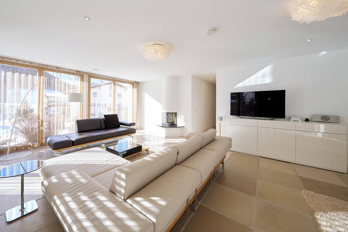 A modern living room with a sofa, a coffee table, and a TV on a cabinet.