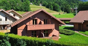 Traditional chalet with a scenic balcony and lush garden views.