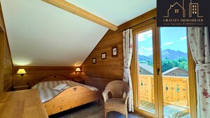 Une pièce chaleureuse en bois, avec un lit, une chaise et une table.