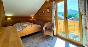 Une pièce chaleureuse en bois, avec un lit, une chaise et une table.